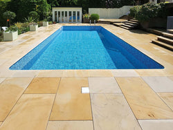 Sawn mint sandstone paving surrounding a swimming pool